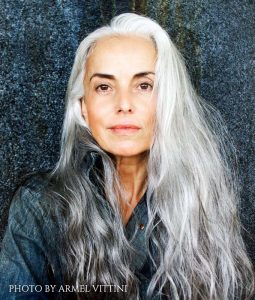 photo of Yazeemenah Rossi, with long gray hair, in a blue denim shirt. Photo By Armel Vittini