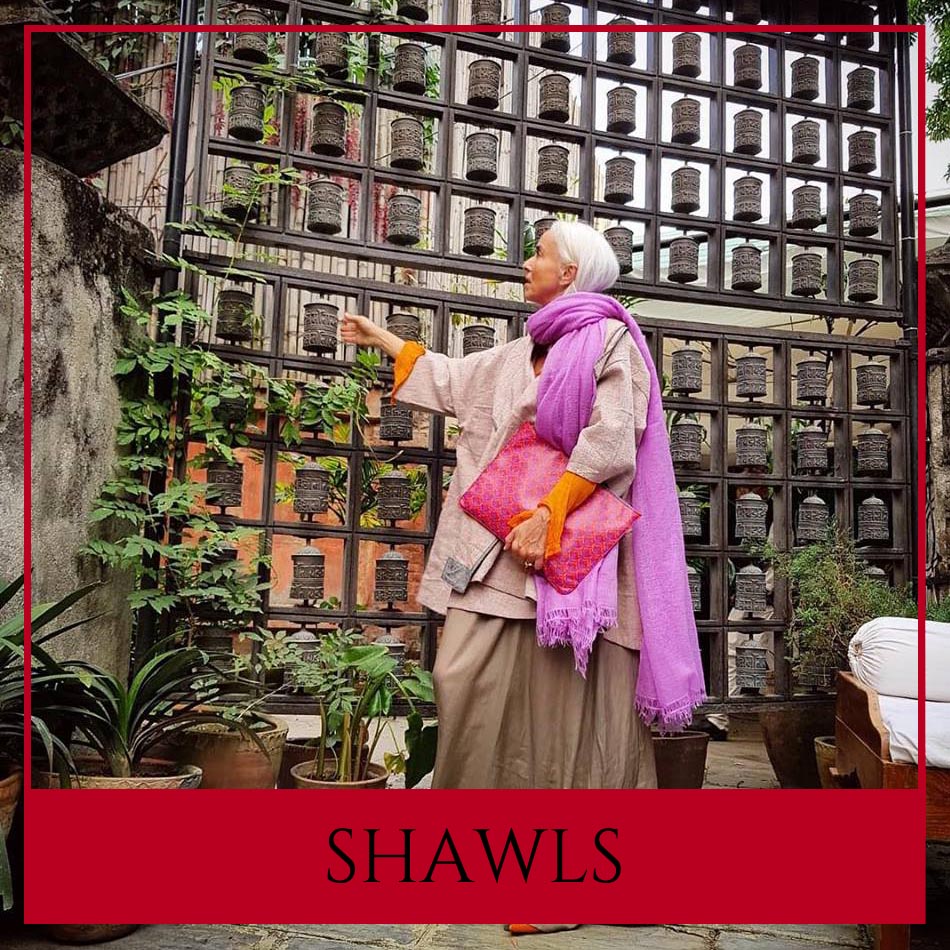 Image of Yazemeenah Rossi in fron of prayer wheels wall with shawls title